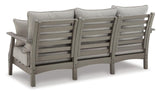 Outdoor seating set with sofa, loveseat, and coffee table by Ashley Furniture, featuring cushioned seats and a modern design.