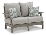 Ashley Furniture Visola outdoor seating set with cushioned chairs and a central table, ideal for patio relaxation.
