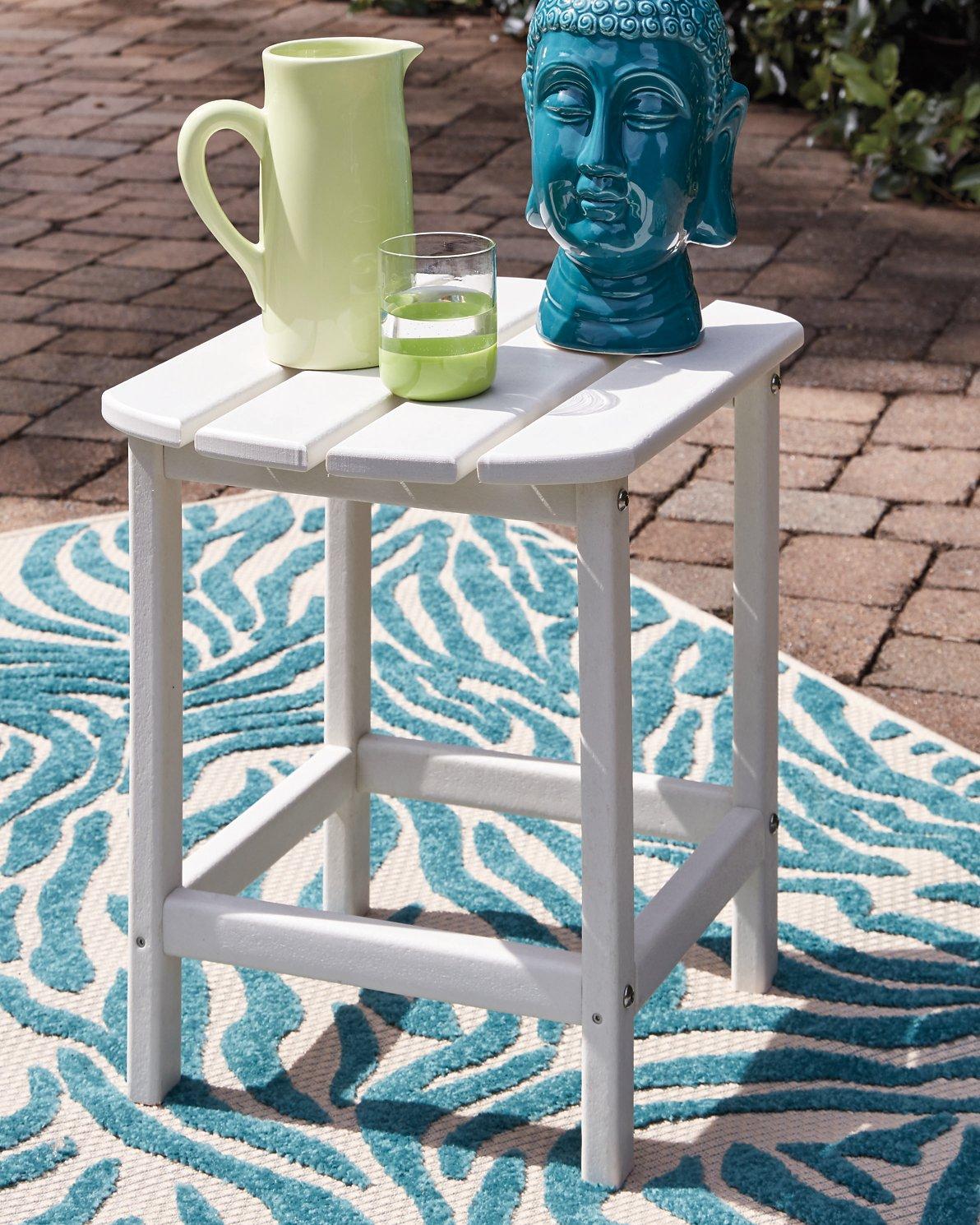 Outdoor table set from Ashley Furniture's Sundown Treasure collection, featuring a table and matching chairs in a garden setting.