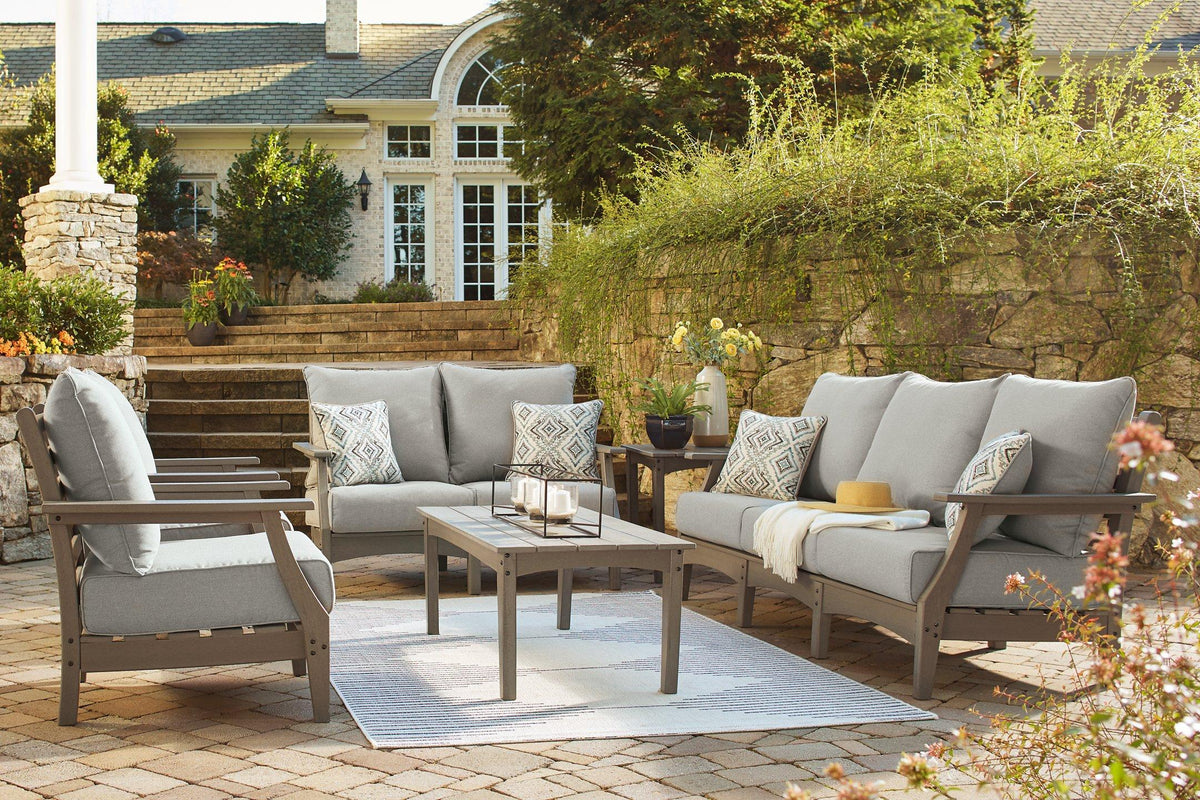 Ashley Furniture Visola outdoor sofa and loveseat set with matching table, featuring cushioned seating and stylish outdoor design.