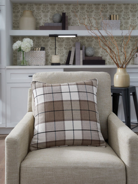 Set of four Ashley Furniture Godricton pillows with decorative fabric covers, shown in a cozy living room setting.