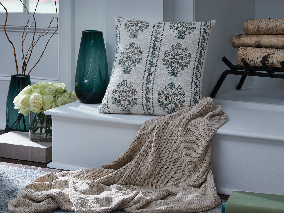 Set of four Ashley Furniture Paulmour pillows with decorative fabric covers, arranged on a neutral-colored sofa.
