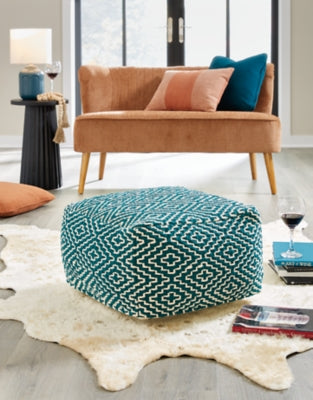 Ashley Furniture Brynnsen Pouf, soft fabric upholstery, modern design, neutral color, compact seating or footrest in a stylish living space.