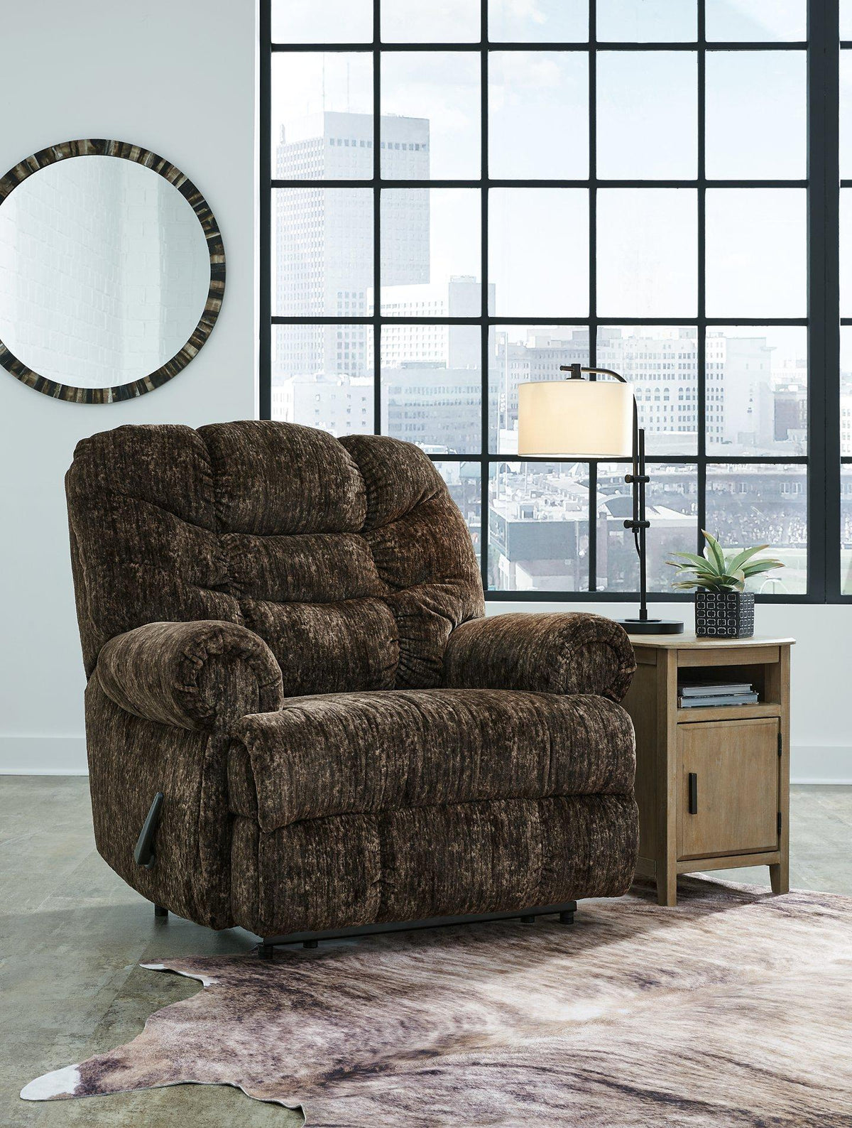 Ashley Furniture Movie Man recliner with plush cushioning and armrests, shown in a relaxed seated position.