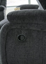 Ashley Furniture Draycoll recliner showing plush fabric, padded armrests, and a comfortable reclining position in a modern living room setting.