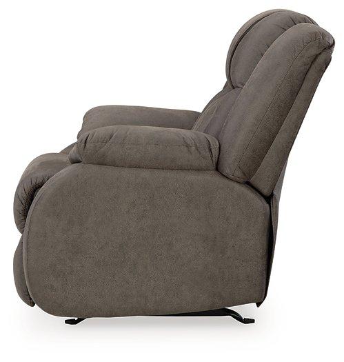 Ashley Furniture First Base recliner showing plush brown upholstery and padded armrests in a modern living room setting.
