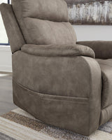 Ashley Furniture Crestmeade Power Lift Recliner in dark leather with plush cushioning and a built-in control panel.
