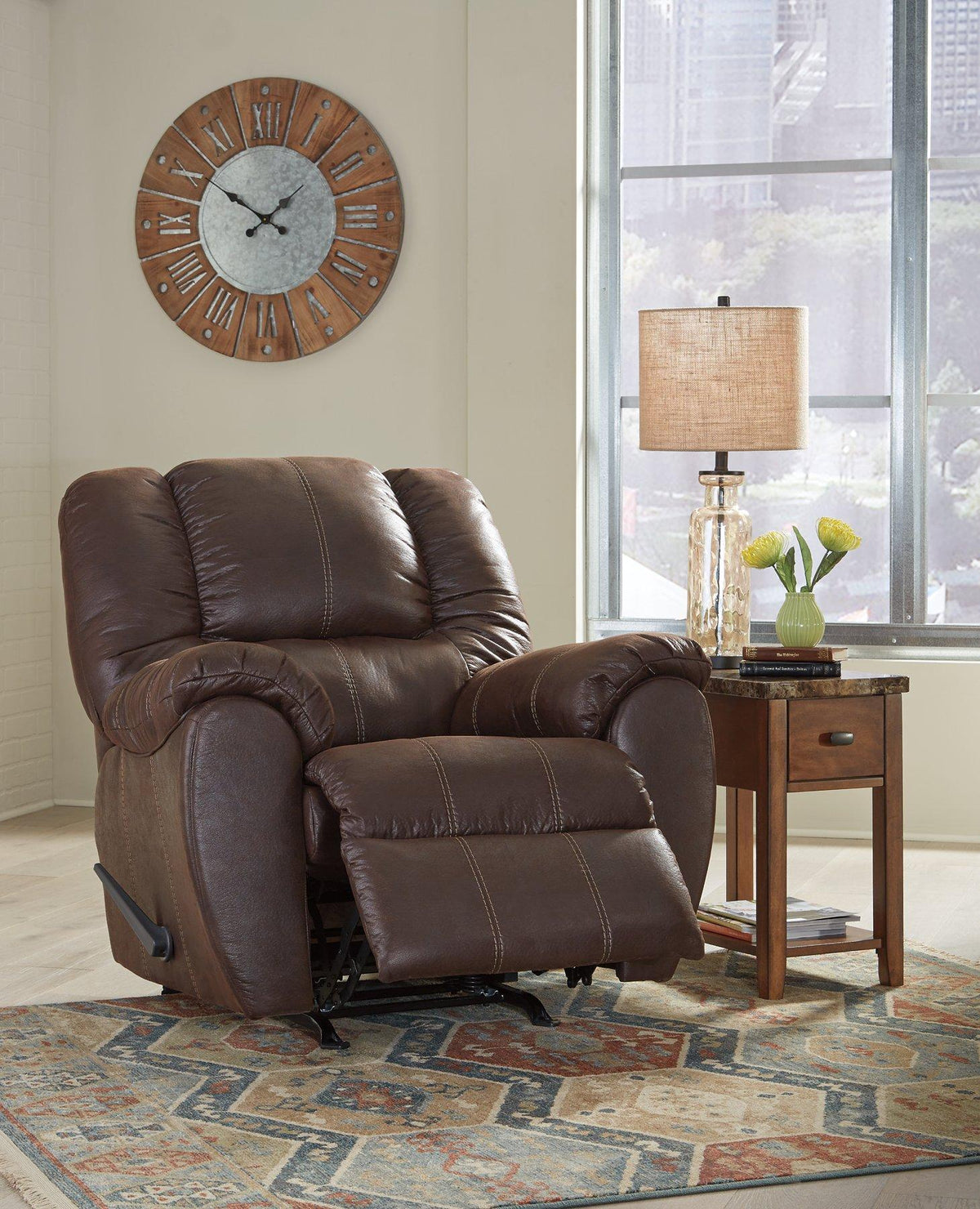 Comfortable brown Ashley McGann recliner with plush cushioning and wooden legs, perfect for living room relaxation.