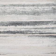 Ashley Furniture Abanett Rug with intricate patterns and warm tones, displayed on a hardwood floor in a stylish living room setting.