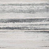 Ashley Furniture Abanett Rug with intricate patterns and warm tones, displayed on a hardwood floor in a stylish living room setting.