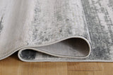 Soft beige Abanett rug by Ashley Furniture with intricate patterns, perfect for adding warmth to living room or bedroom floors.