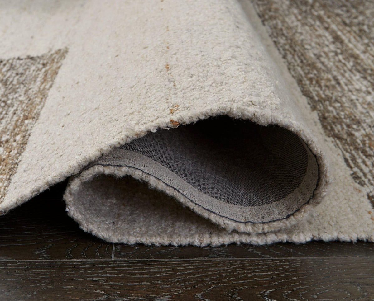 Ashley Furniture Barus Rug with intricate woven pattern in neutral tones, showcasing its soft, textured surface for home decor.