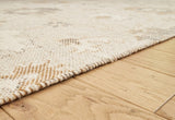 Close-up of the textured Calkin Rug by Ashley Furniture, showcasing intricate woven patterns and rich neutral tones.