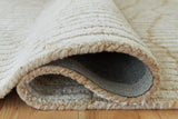 Close-up of Ashley Furniture Jaseena area rug showing intricate woven pattern and soft texture in neutral tones.