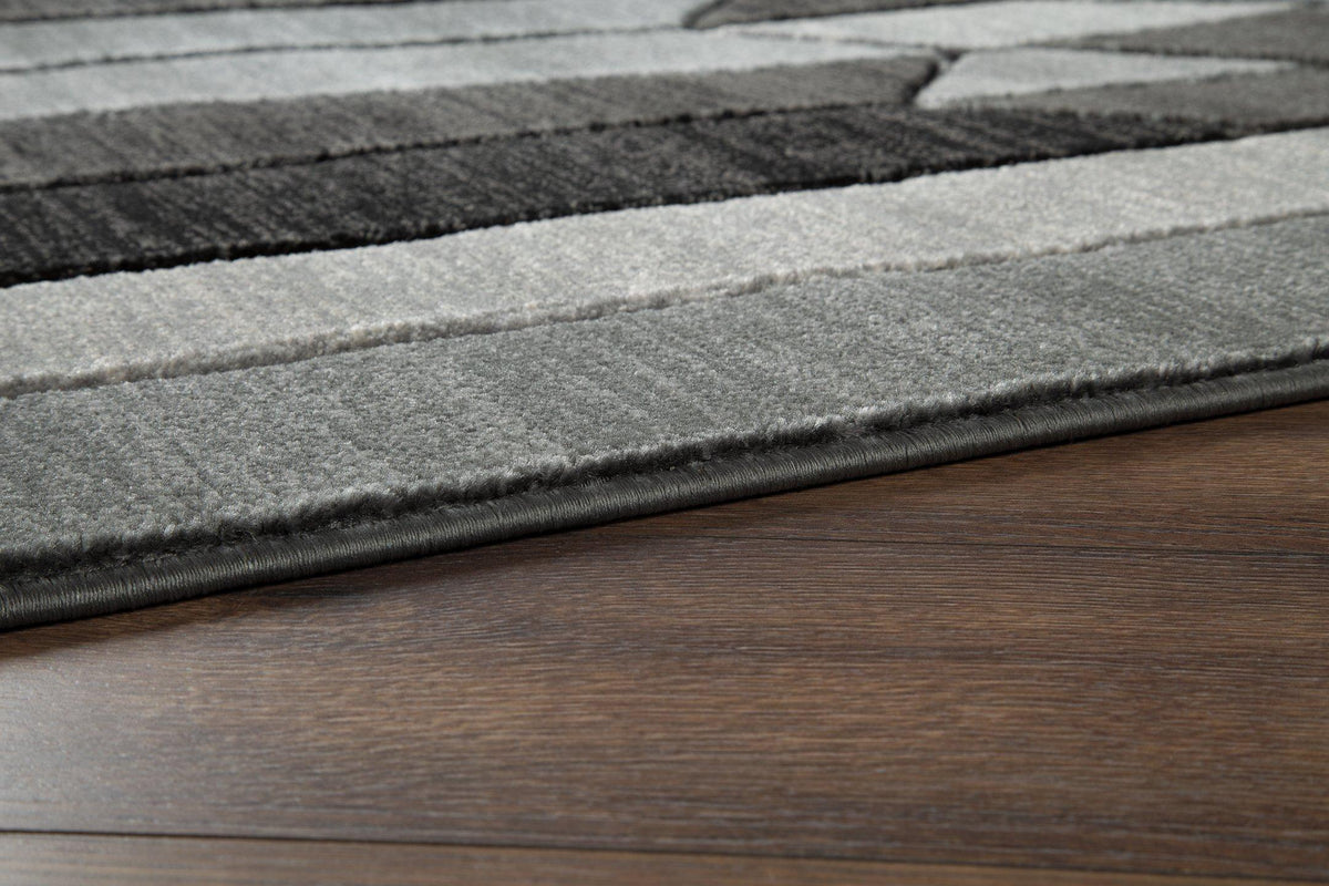 Ashley Furniture Chayse 5' x 6'7" rug with intricate pattern and soft texture, ideal for living rooms and bedrooms.