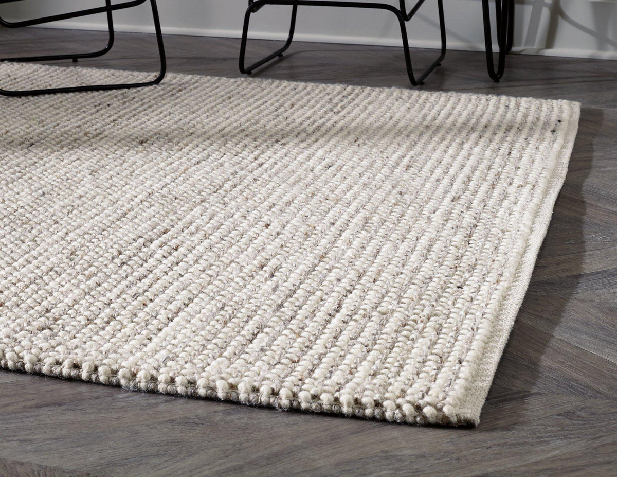 Ashley Furniture Jossick 7'8" x 10' rug with intricate patterns and neutral tones, perfect for adding style to living spaces.