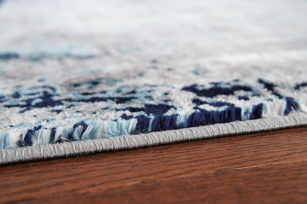 Ashley Furniture Leonelle 5'3" x 7'3" rug featuring a stylish pattern in neutral tones for living room or bedroom decor.