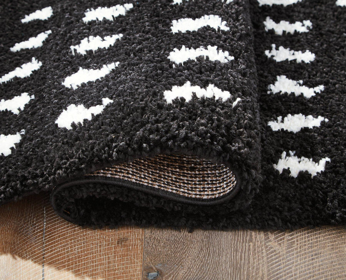 Ashley Furniture Minston 5' x 7' rug with intricate patterns and soft texture, ideal for enhancing living room decor.