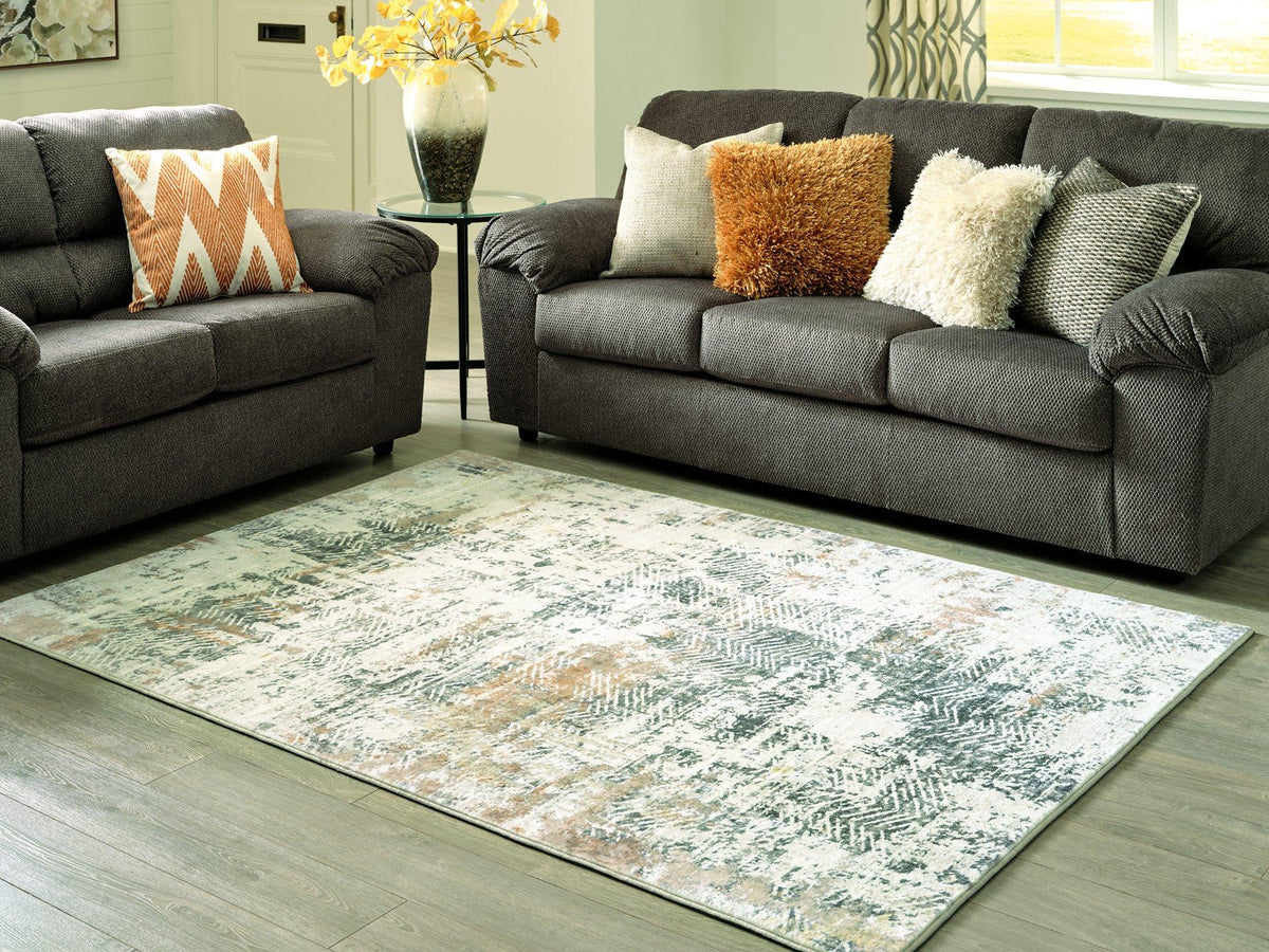 Redlings 5x7 rug from Ashley Furniture featuring vibrant red and neutral tones with intricate patterns, perfect for living rooms or bedrooms.