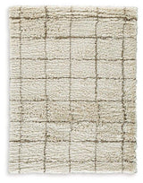 Wrenlow Rug by Ashley Furniture featuring a plush, patterned design in neutral tones, suitable for living room or bedroom decor.