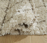 Ashley Furniture Wrenlow Rug with intricate patterns in warm neutral tones, ideal for living room or bedroom decor.