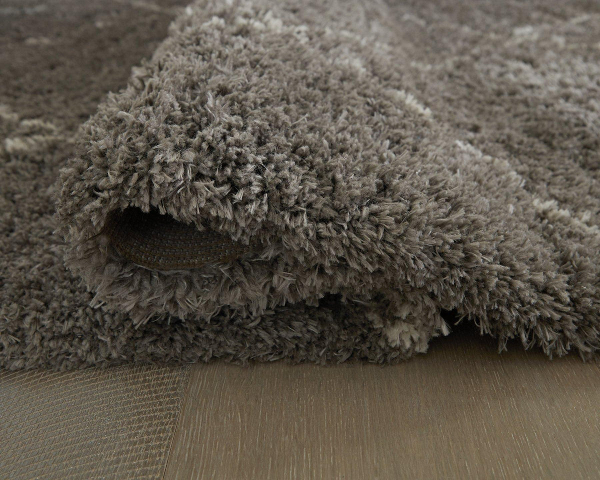 Soft beige Wrenlow Rug by Ashley Furniture with intricate woven patterns, perfect for enhancing living room decor.