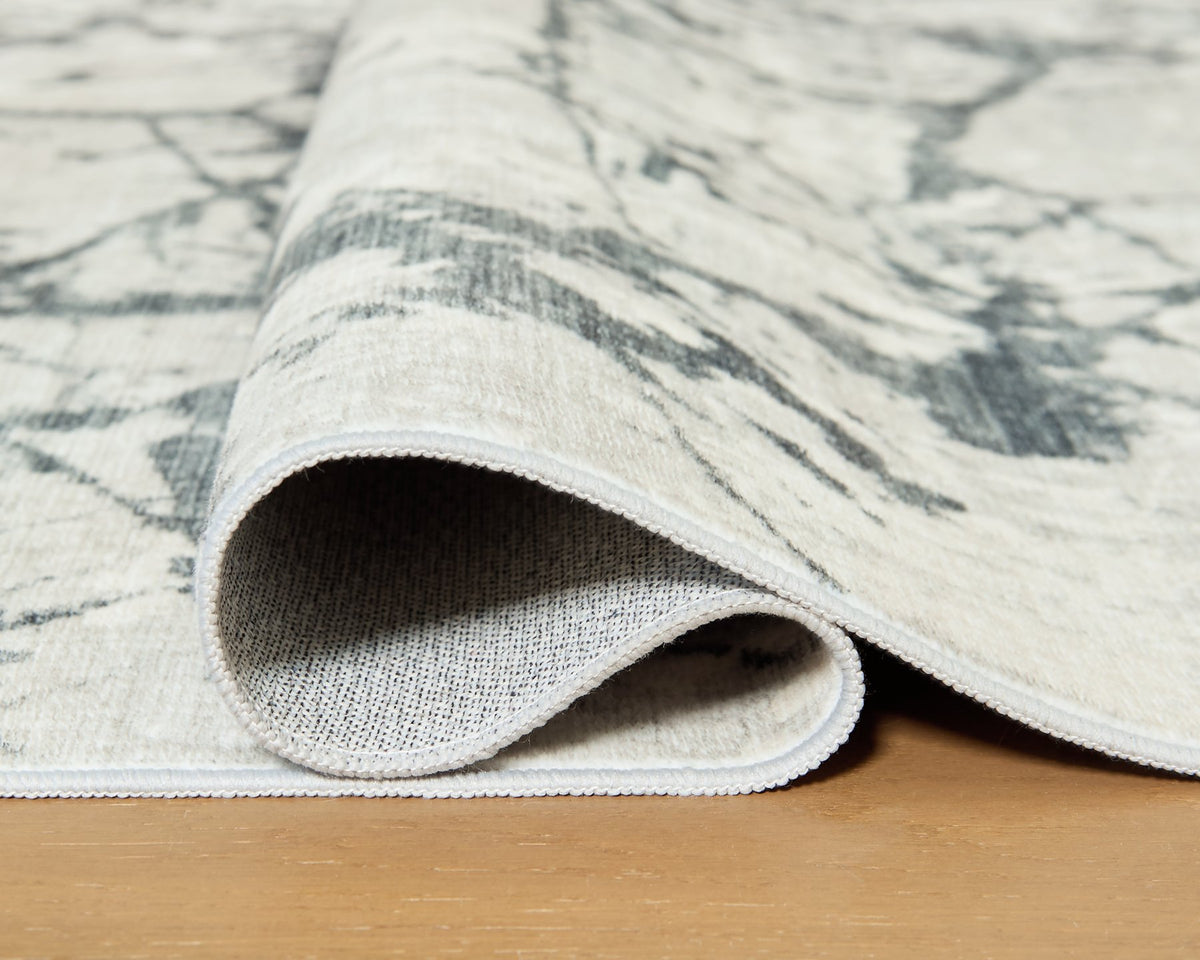 Medium Ashley Furniture Tobinbury washable area rug with detailed pattern, showcasing soft, durable fabric in natural tones.