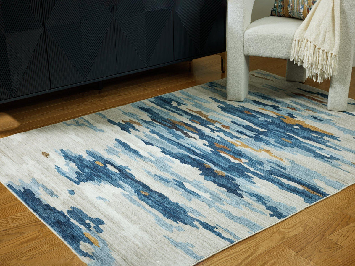 Medium washable rug by Ashley Furniture with a soft, patterned design, perfect for modern living spaces.