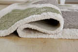 Close-up of the Anburgh Rug by Ashley Furniture, showcasing intricate woven patterns and rich textures.