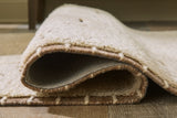 Close-up of Ashley Furniture Clayman Rug showing its textured woven pattern and earthy tones.