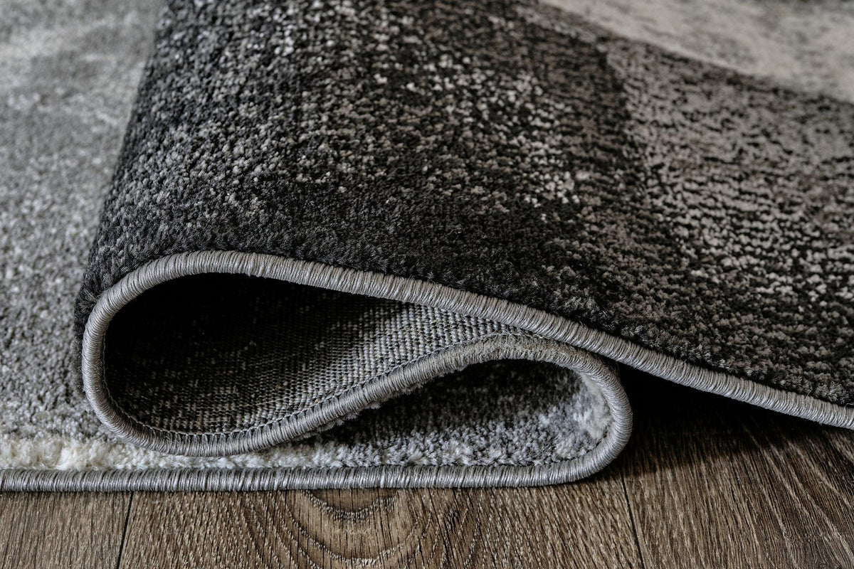Medium Ashley Furniture Brycebourne 5'3" x 7'7" rug with intricate pattern and soft texture, ideal for enhancing living room decor.