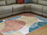 Medium Ashley Furniture Chanleigh washable 5x7 area rug with intricate pattern, shown in a cropped view.