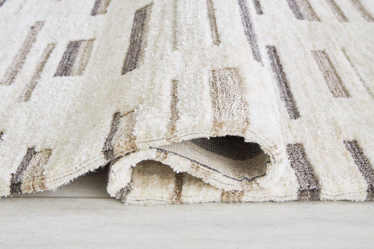 Medium Leesdale 5x7 rug by Ashley Furniture featuring intricate patterns and soft textures for living room decor.