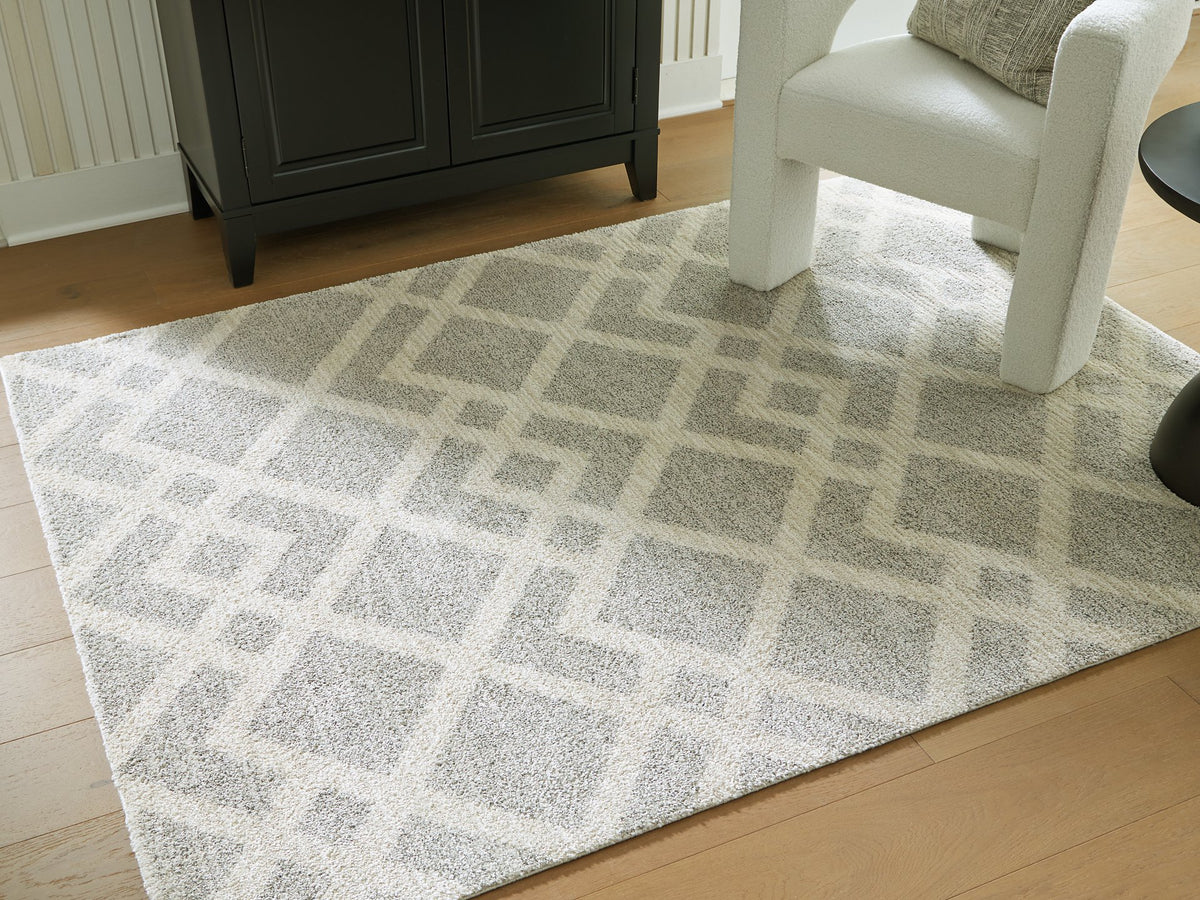 Medium Ashley Furniture Unawick Rug with a textured, neutral design suitable for living rooms or bedrooms.