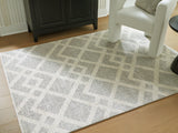 Medium Ashley Furniture Unawick Rug with a textured, neutral design suitable for living rooms or bedrooms.