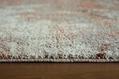 Close-up of Ashley Furniture Jadenburg Rug showing intricate woven patterns and rich textures in neutral tones.