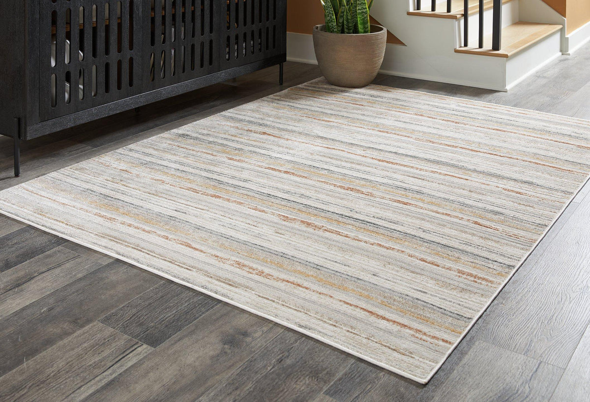 Medium Ashley Furniture Artney Rug with intricate patterns, showcasing soft textures and warm tones for cozy living spaces.