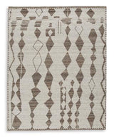 Medium Ashley Furniture Brettler Rug with intricate woven pattern in neutral tones on a light-colored floor.