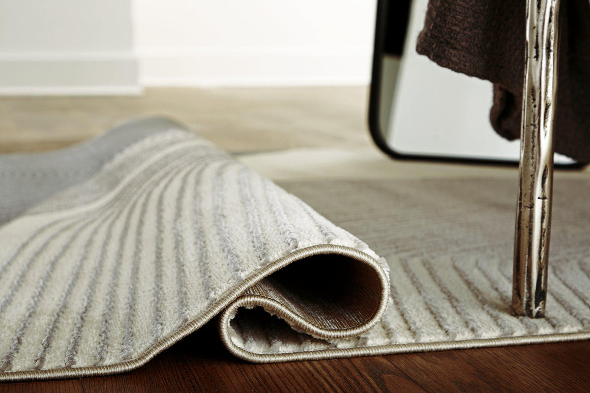 Medium Ashley Furniture Winderburg Rug with intricate pattern and neutral tones, perfect for living room or bedroom decor.