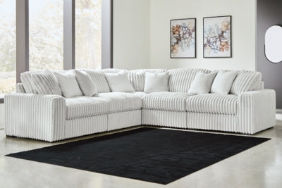 Ashley Furniture Stupendous sectional sofa with plush cushions and neutral upholstery, shown in a spacious living room setting.