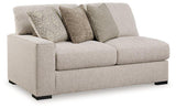 Ashley Furniture Ballyton sectional sofa with plush cushions and neutral fabric, shown in a spacious living room setting.