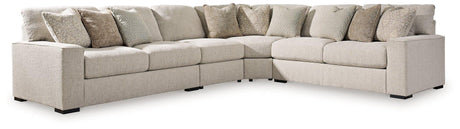 Ashley Furniture Ballyton Sectional sofa with plush cushions and neutral fabric, arranged in a spacious living room setting.