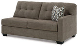 Ashley Mahoney 2-piece sleeper sectional with chaise, beige fabric, modern design, and plush cushions in a stylish living room setting.