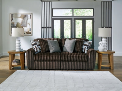 Ashley Furniture Midnight-Madness sectional sofa with dark upholstery, plush cushions, and modern design, shown in a cropped image.