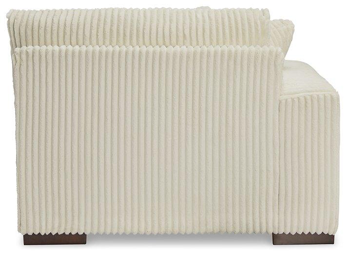 Ashley Furniture Lindyn sectional sofa with plush fabric, multiple cushions, and a modern design in a spacious living room setting.
