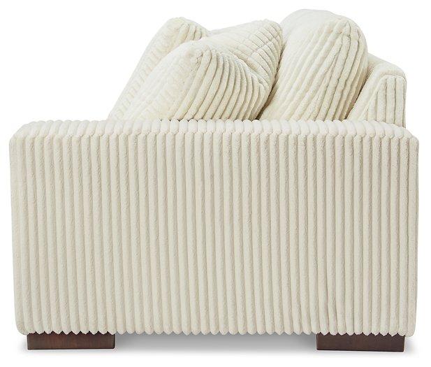 Ashley Furniture Lindyn sectional sofa with plush fabric and modern design, shown in a spacious living room setting.