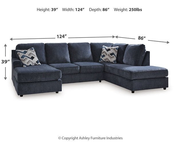Ashley Furniture Albar Place sectional sofa with plush cushions and neutral fabric, shown in a spacious living room setting.