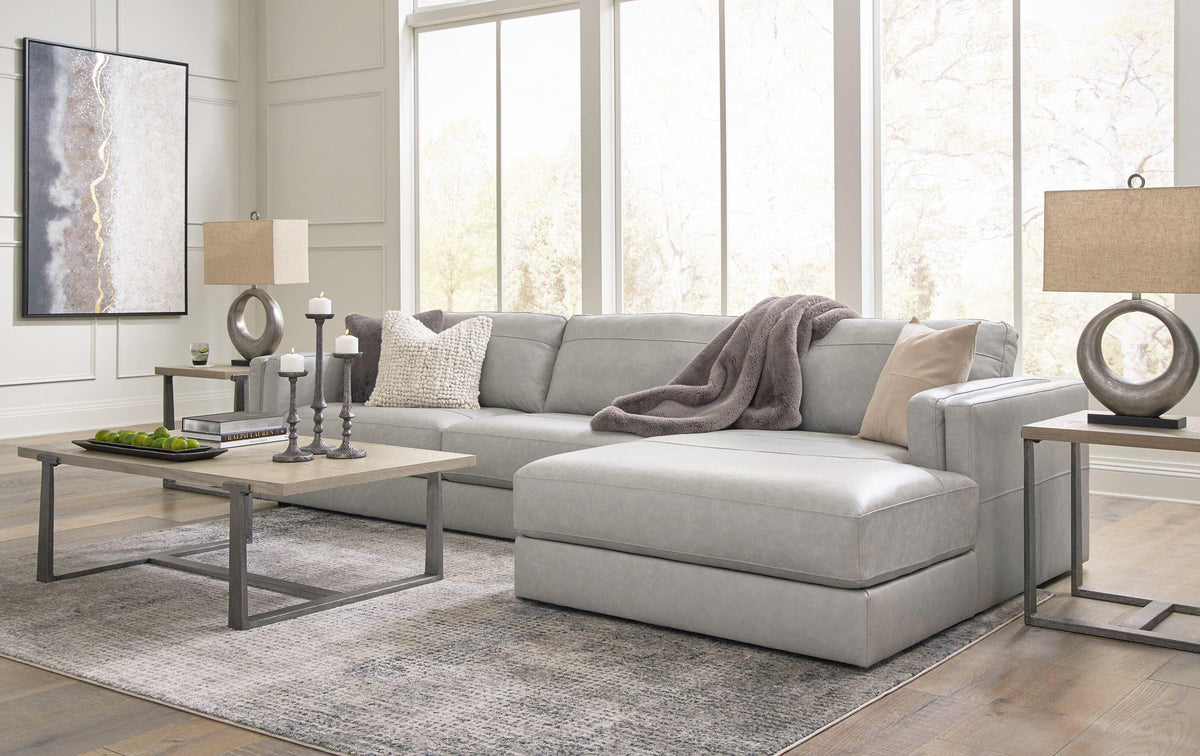 A Ashley Furniture Amiata sectional with chaise featuring plush cushions and modern design in a cozy living room setting.