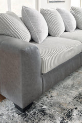 Ashley Furniture Clairette Court Sectional with chaise, featuring plush cushions and modern design in a cozy living room setting.