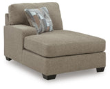 Ashley Furniture Newellen sleeper sectional with chaise, featuring plush cushions and a modern design in a cozy living room setting.
